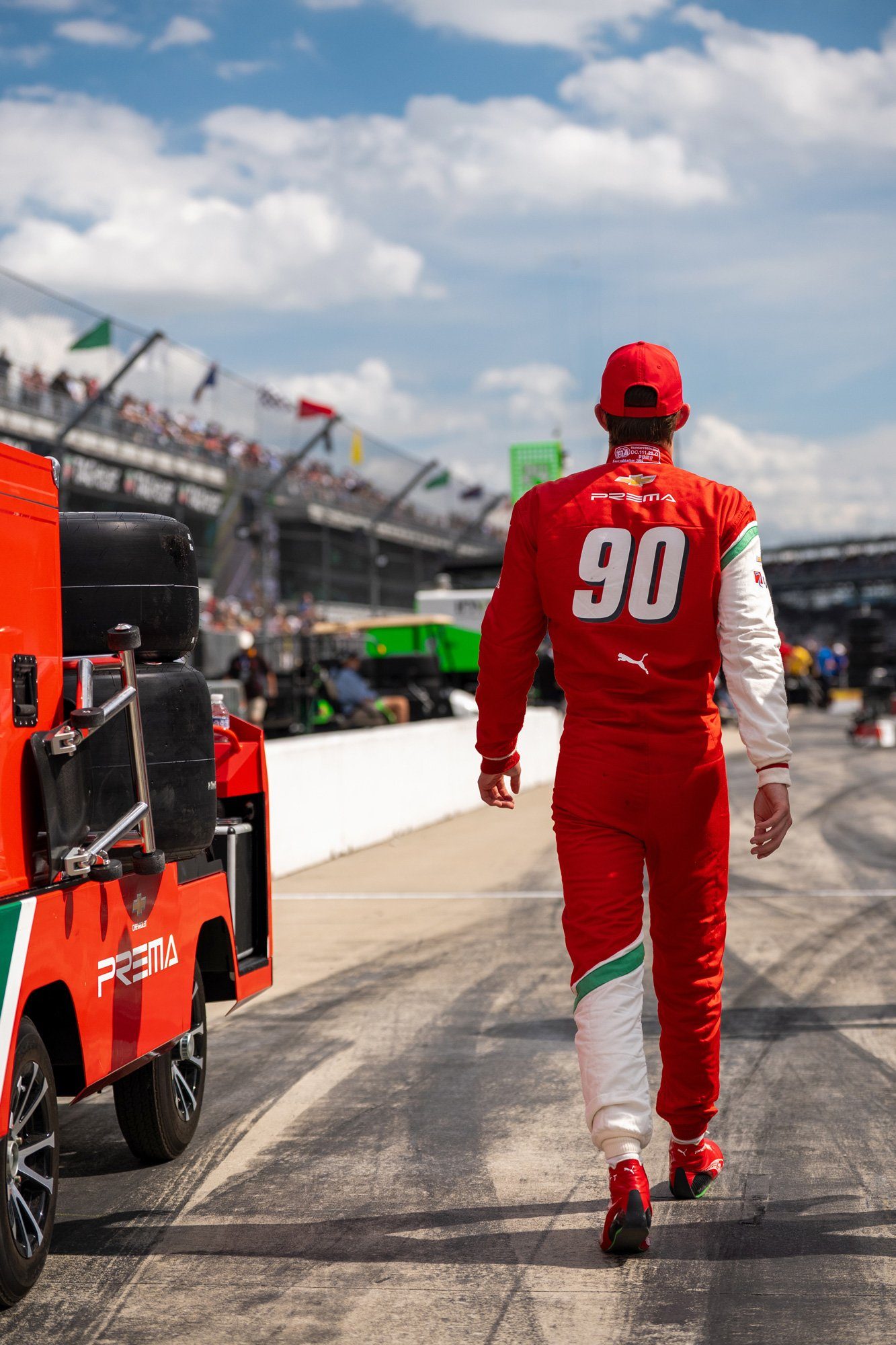 A PREMA crew member walking the pit lane behind the cart