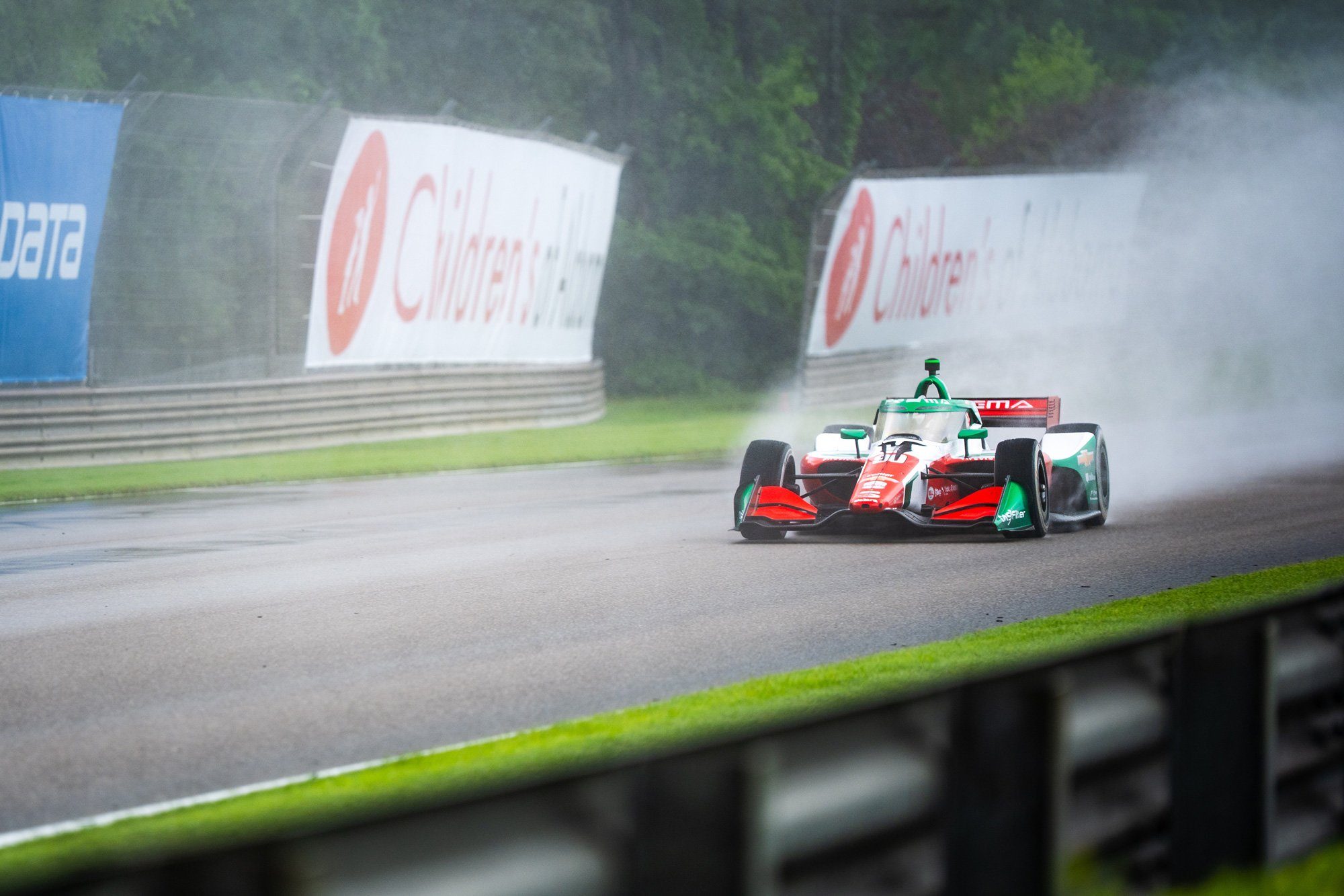 The PREMA car running through spray on a wet road course